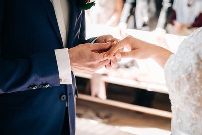 Midsection of couple holding hands