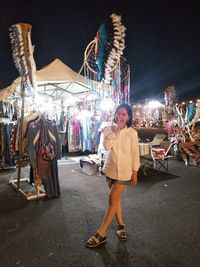 Full length portrait of woman standing at night