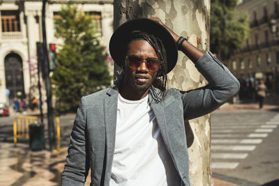 Portrait of young man in hat at city