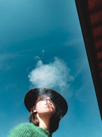 Portrait of man smoking against sky