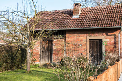 Old house by building against sky