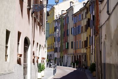 People walking on narrow street amidst buildings in town