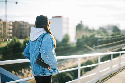 Rear view of woman standing on bridge