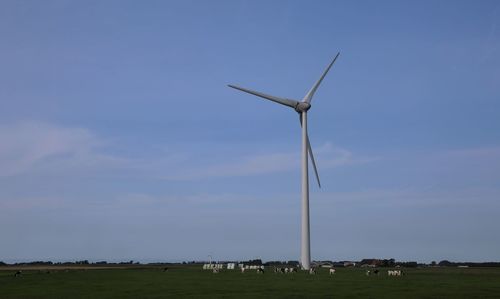 Windmill on field against sky