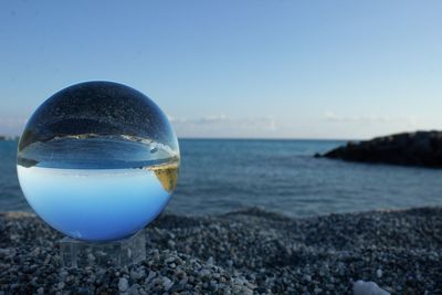 Close-up of pebbles on beach against sky