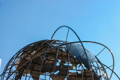 Low angle view of ferris wheel against clear blue sky