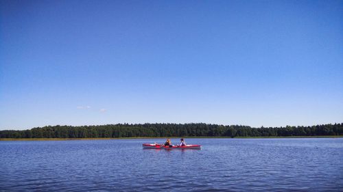 Scenic view of lake against clear blue sky