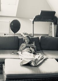 Woman sitting on sofa at home