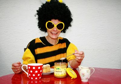 Portrait of smiling man holding coffee cup on table