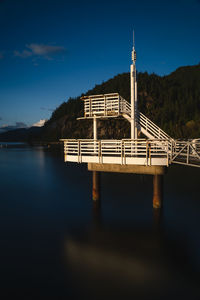 Bridge over lake against blue sky