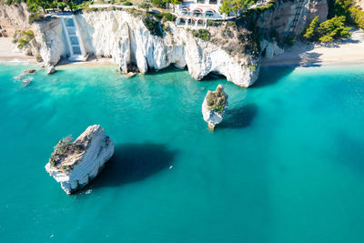 High angle view of people on rock in sea