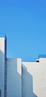 Low angle view of modern building against blue sky