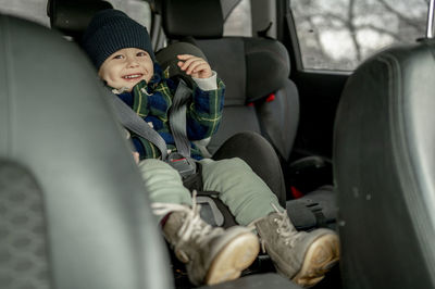 Happy cute boy in car safety seat