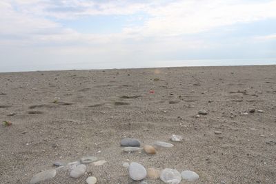 Close-up of pebbles on beach against sky