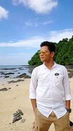 Young man standing against sea at beach