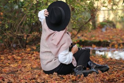 Full length of senior man sitting on leaves