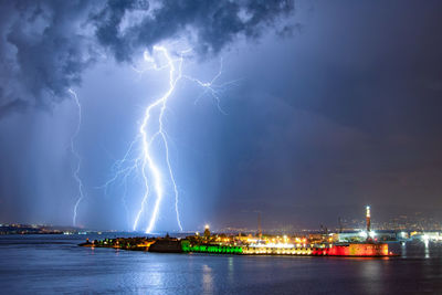 Lightning over sea against sky at night