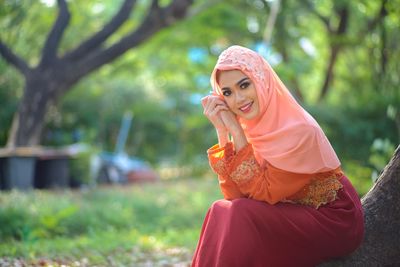 Woman looking away while sitting outdoors