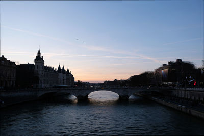Bridge over river in city against sky