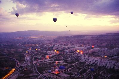 Hot air balloons flying over landscape against sky