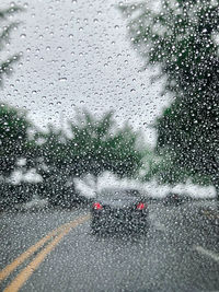 Raindrops on road seen through wet window