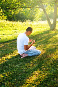 Rear view of man sitting on field