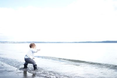 Full length of boy on beach against sky during winter
