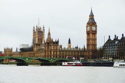 Bridge over river in city against sky