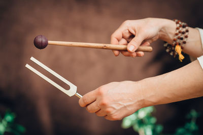 Cropped hands of person holding musical equipment outdoors