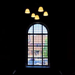 Low angle view of illuminated window in dark room