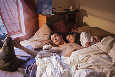 Young couple lying together in bed