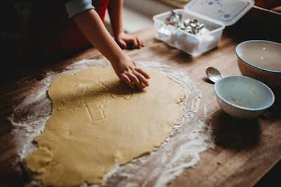 Close up of a child's hand making christmas cookies with a cutter