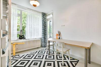 View of table and chair by wall
