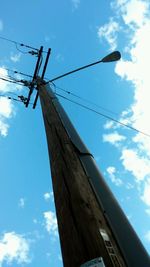 Low angle view of electricity pylon against blue sky