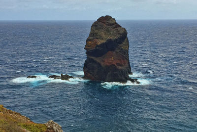 Rock formation in sea against sky