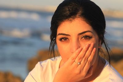 Portrait of beautiful young woman against sea