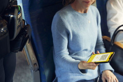 Woman holding cell phone with e-ticket