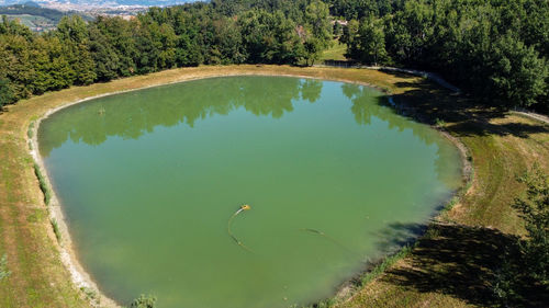 Aerial view from the drone of a little lake in italian hills with woods