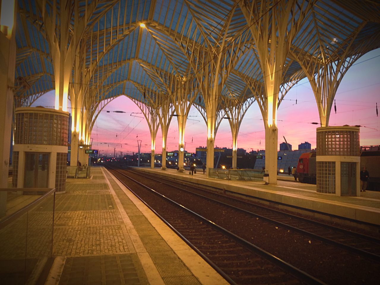 railroad track, railroad station, railroad station platform, rail transportation, public transportation, transportation, architecture, built structure, train - vehicle, travel, indoors, illuminated, sunset, the way forward, building exterior, sky, train, incidental people, railway station, passenger train