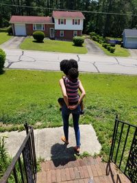 Rear view of woman and child standing in front of steps overlooking the neighborhood 