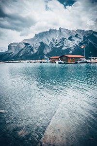 Scenic view of river by snowcapped mountains against sky