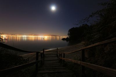 View of illuminated pier at night