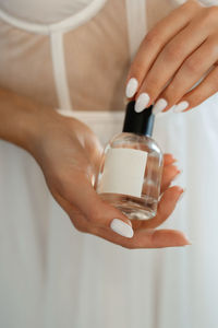 Cropped hand of woman holding bottle