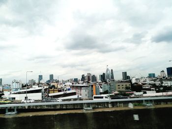 View of cityscape against cloudy sky