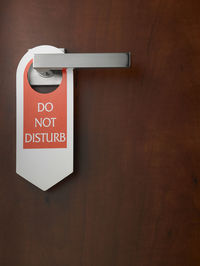 Close-up of do not disturb sign hanging on door handle