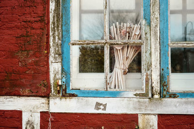 Bundle of stick on closed window of abandoned house