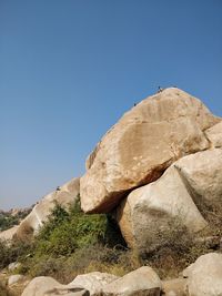 Low angle view of rock formation against clear blue sky