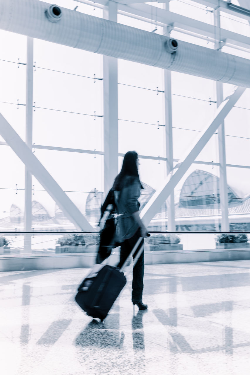 FULL LENGTH OF WOMAN WALKING IN AIRPORT