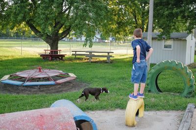 Boy standing on tire at park