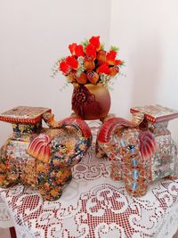 Close-up of flowers in vase on table against wall